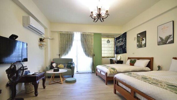A room with a bed, a desk, a chair, a television, and a window with curtains. - Rover 21 Inn (Taitung)