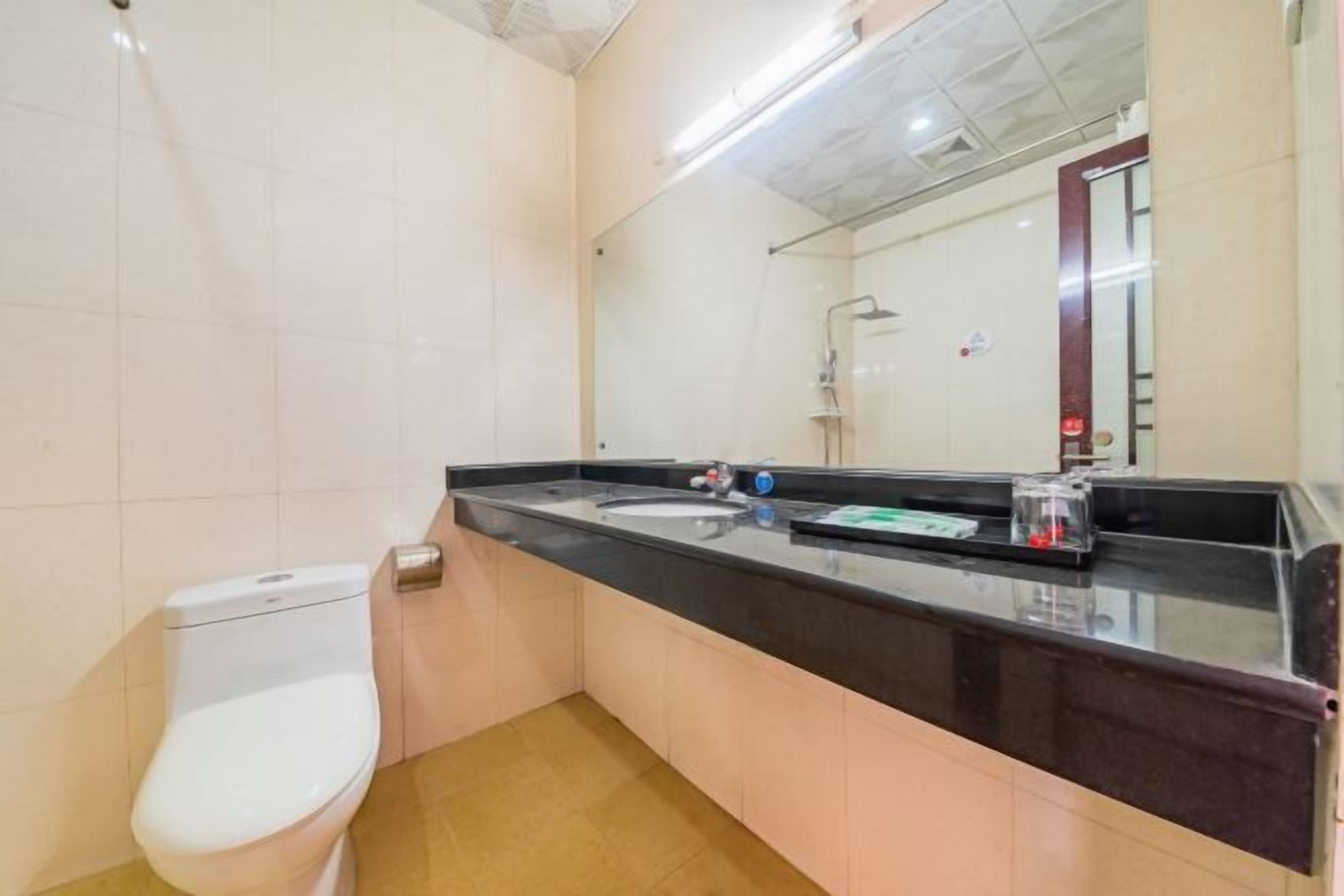 A bathroom with a toilet, a sink, and a shower.