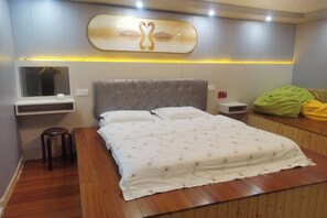 A modern bedroom with a large bed, a bedside table, a mirror, and a wall-mounted artwork. - Qingshui Hostel (Shanghai)