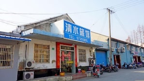 A building with a blue signboard and a red door. - Qingshui Hostel (Shanghai)