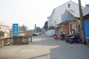 Una calle con motocicletas estacionadas, un letrero azul y edificios.