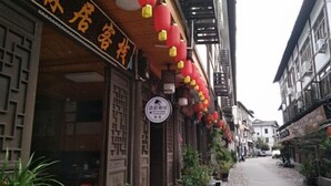 A narrow street lined with traditional buildings, some with signage indicating local businesses. - Yongjia Nanxi Jiangsenju Homestay (Yongjia)