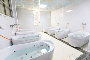 A modern bathroom with multiple tubs and showers, a tiled floor, and a vent system. - Queen's Mountain Oxygen Heart Valley Mountain Resort (Lianshan)