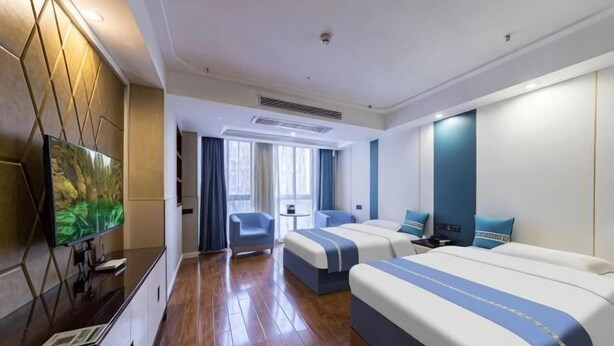 A hotel room with a TV, two beds, a desk, and a window. - nanyuan e home hotel (liu an Railway Station Hotel ) ) (Lu'an)