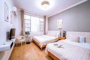 A hotel room with two beds, a desk, a chair, a TV, and a window with curtains. - Loving Return · Cozy Stay Guesthouse（Dali Ancient Town, Yu'er Road Branch） (Dali City)