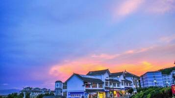A coastal town with buildings, a clear sky, and a sunset.