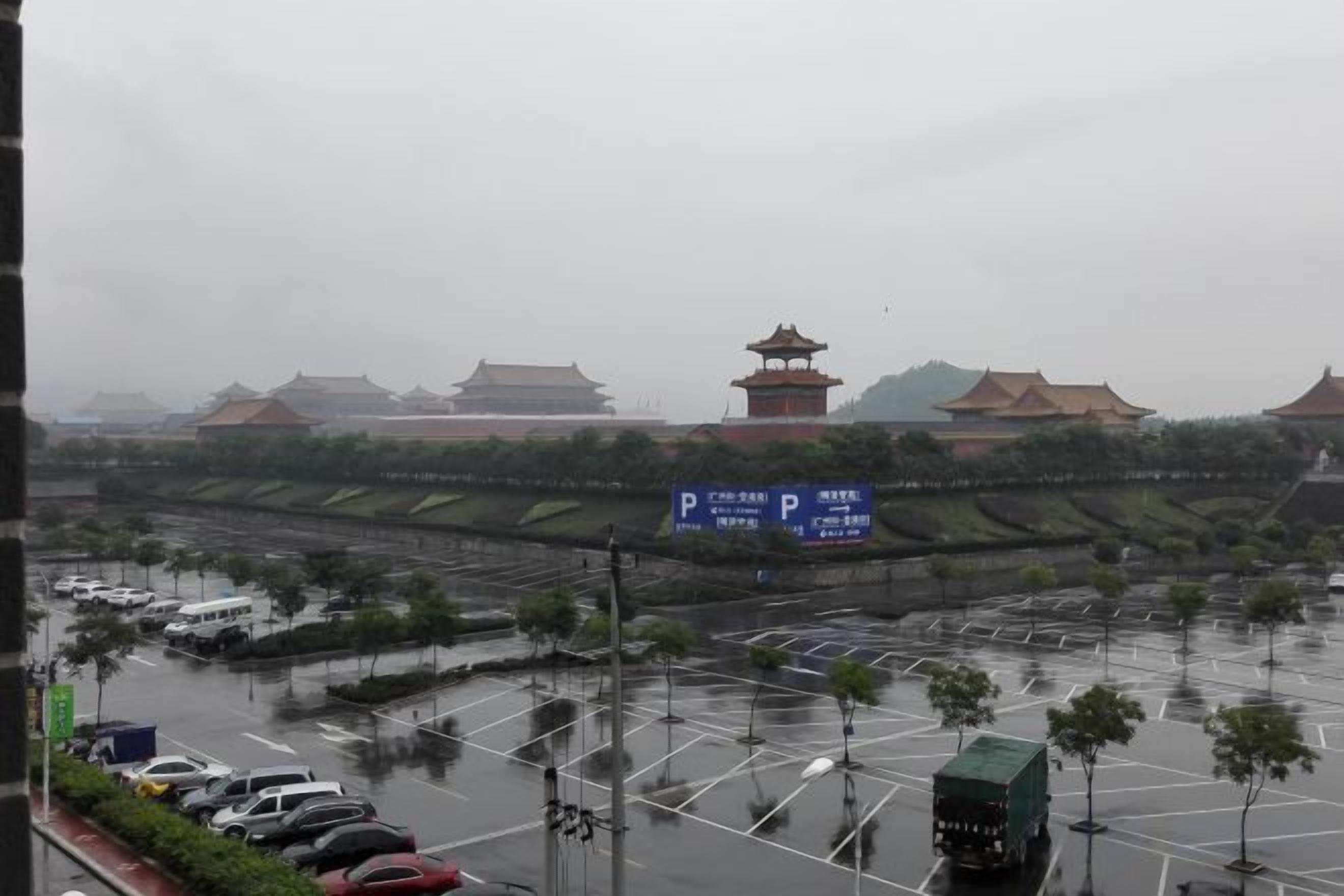 A parking lot with vehicles, a traditional building with a pagoda-style roof, and a sign with Chinese characters.