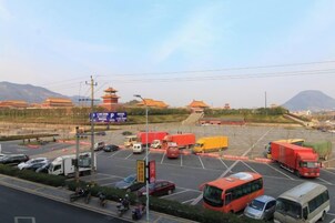 Estacionamento com veículos e vista distante de arquitetura tradicional.