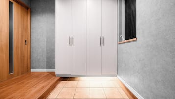 A room with a wardrobe, a wooden floor, and a textured wall.