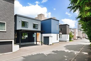 A modern residential street with contemporary houses, a clear sky, and a tree-lined sidewalk. - THE GRACIOUS (Sapporo)