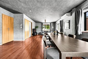 A spacious conference room with a long wooden table, grey walls, and a concrete ceiling. - THE GRACIOUS (Sapporo)
