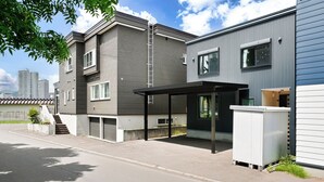 A modern residential building with a covered outdoor area, a visible staircase, and a garage. - THE GRACIOUS (Sapporo)