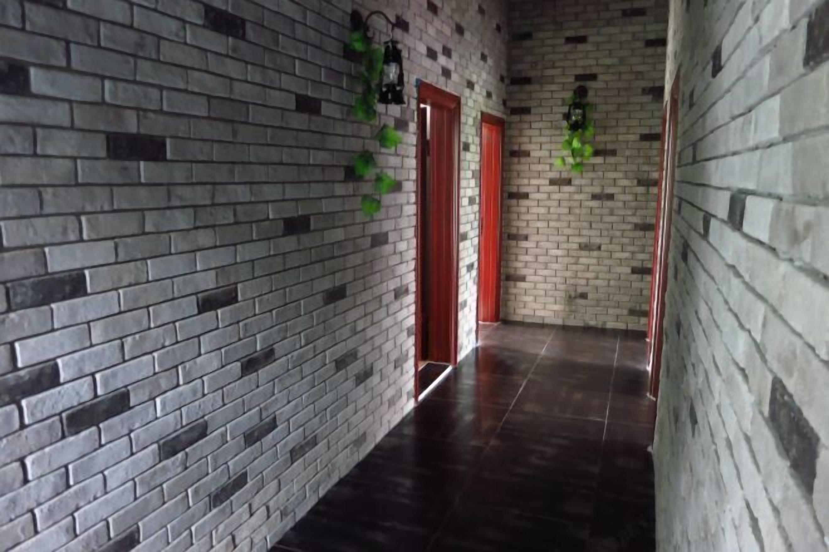 A hallway with brick walls and a dark floor.