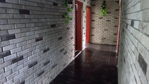A hallway with brick walls and a dark floor. - Yellow Cloth Reflection Inn (Yangshuo)