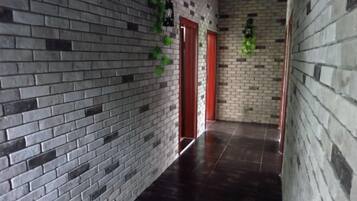 A hallway with brick walls and a dark floor.