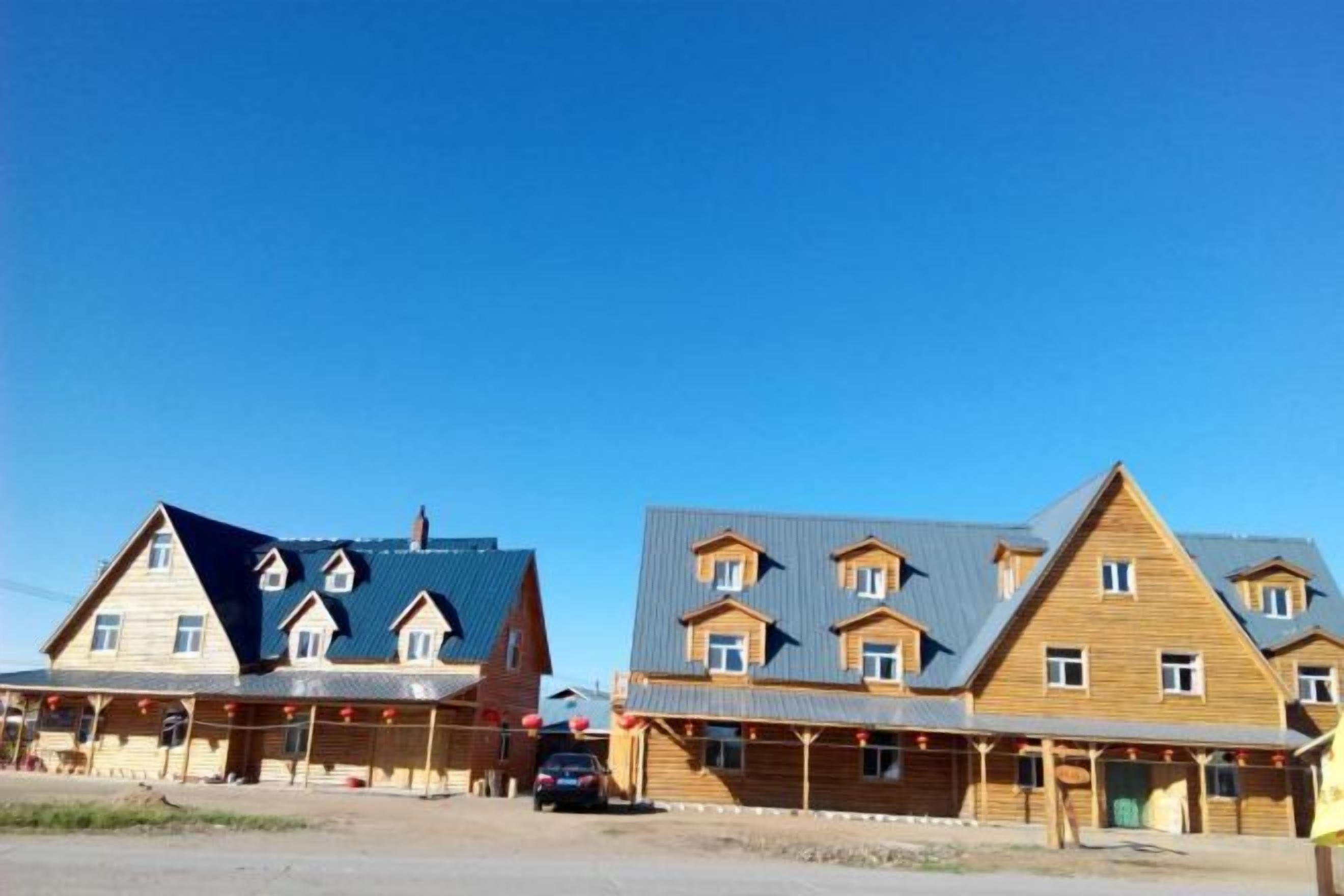 A row of wooden buildings with multiple stories and a flat roof design.