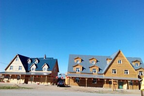 A row of wooden buildings with multiple stories and a flat roof design.