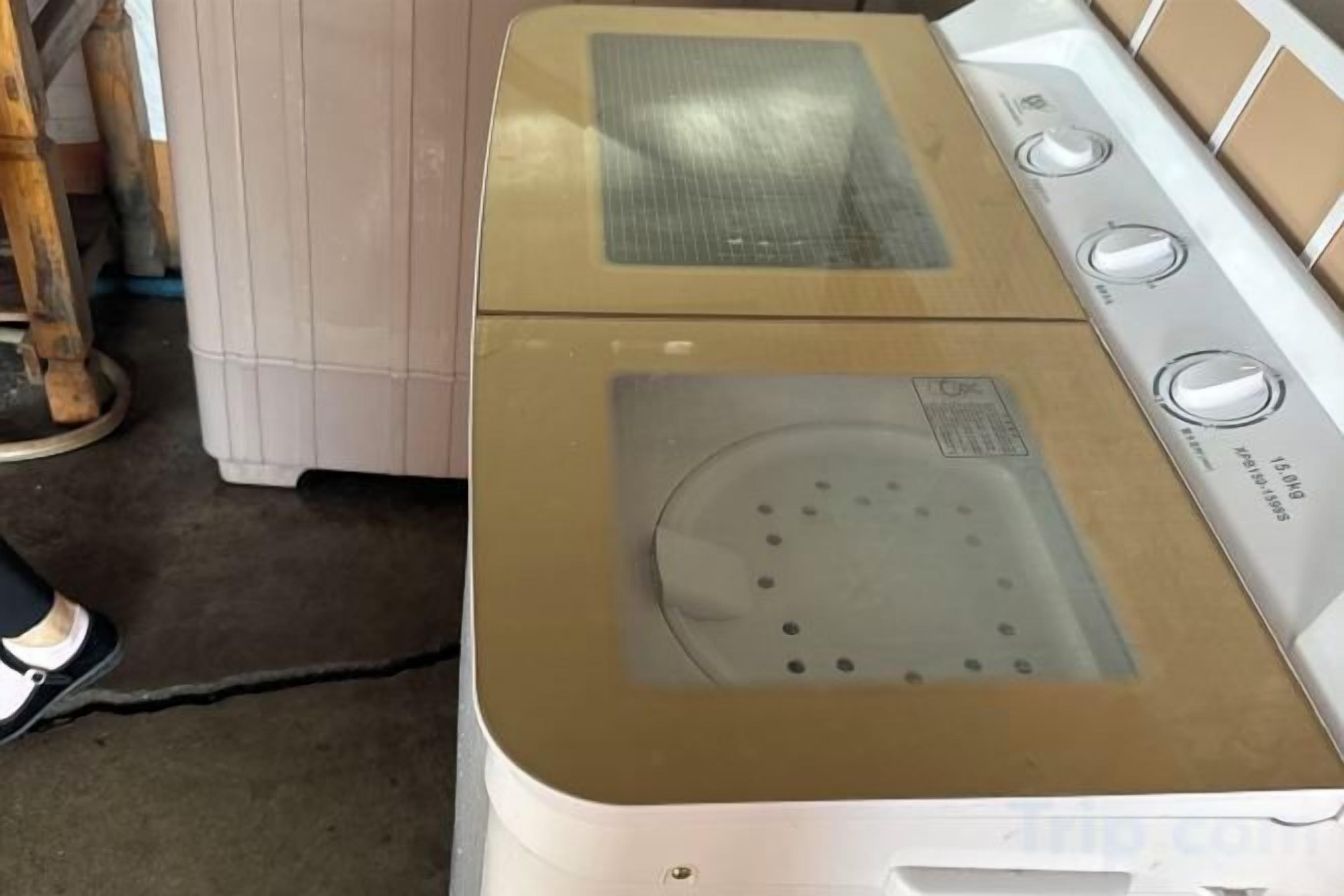 A white washing machine with a beige top, a control panel, and a transparent door.