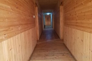 Un pasillo de madera con una puerta al final.