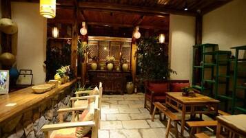 A traditional interior with wooden furniture, a stone floor, and hanging light fixtures.