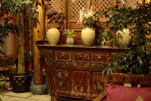Een houten kast met meerdere lades en een vaas met bloemen.