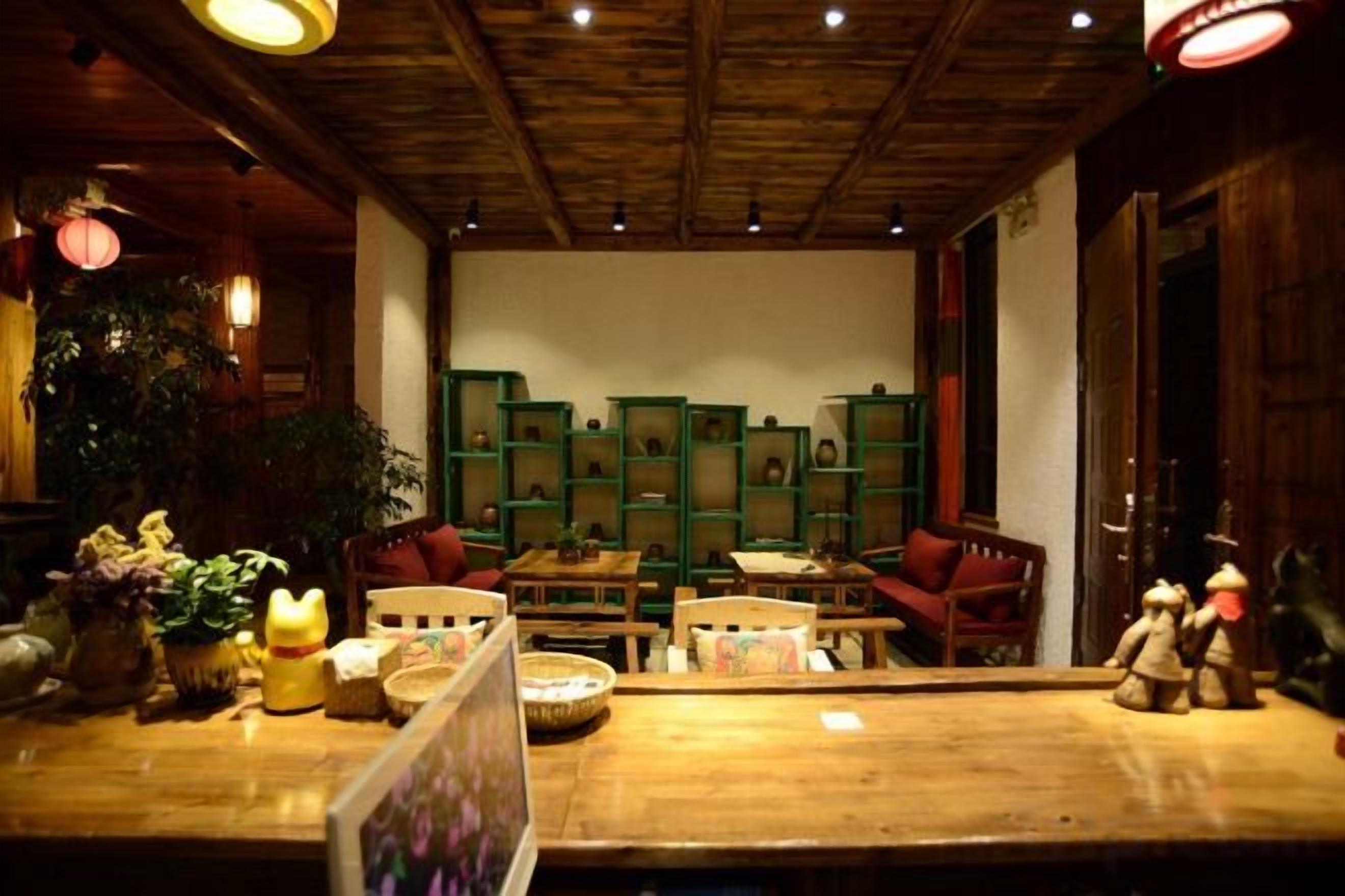 Un interior acogedor con muebles de madera, una estantería verde y techo de madera.