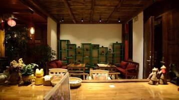 Un interior acogedor con muebles de madera, una estantería verde y techo de madera.