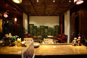 A cozy interior with wooden furniture, a green bookshelf, and a wooden ceiling.