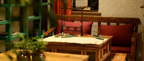 A cozy room with a wooden table, a bench, and a bookshelf.