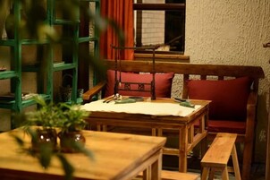 A cozy room with a wooden table, a bench, and a bookshelf.