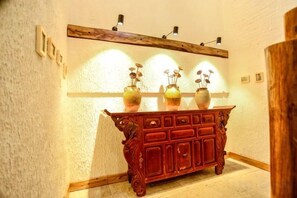 A wooden cabinet with decorative vases and wall-mounted lights. - Huayutang Renwen Inn (Luoping)