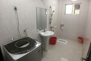 A bathroom with a sink, mirror, shower, and a black appliance. - Home of Little Bee Guesthouse (Hezhou)