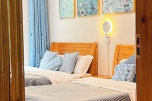 A double bed with a wooden headboard, two bedside tables, and a bedside lamp. - Home of Little Bee Guesthouse (Hezhou)