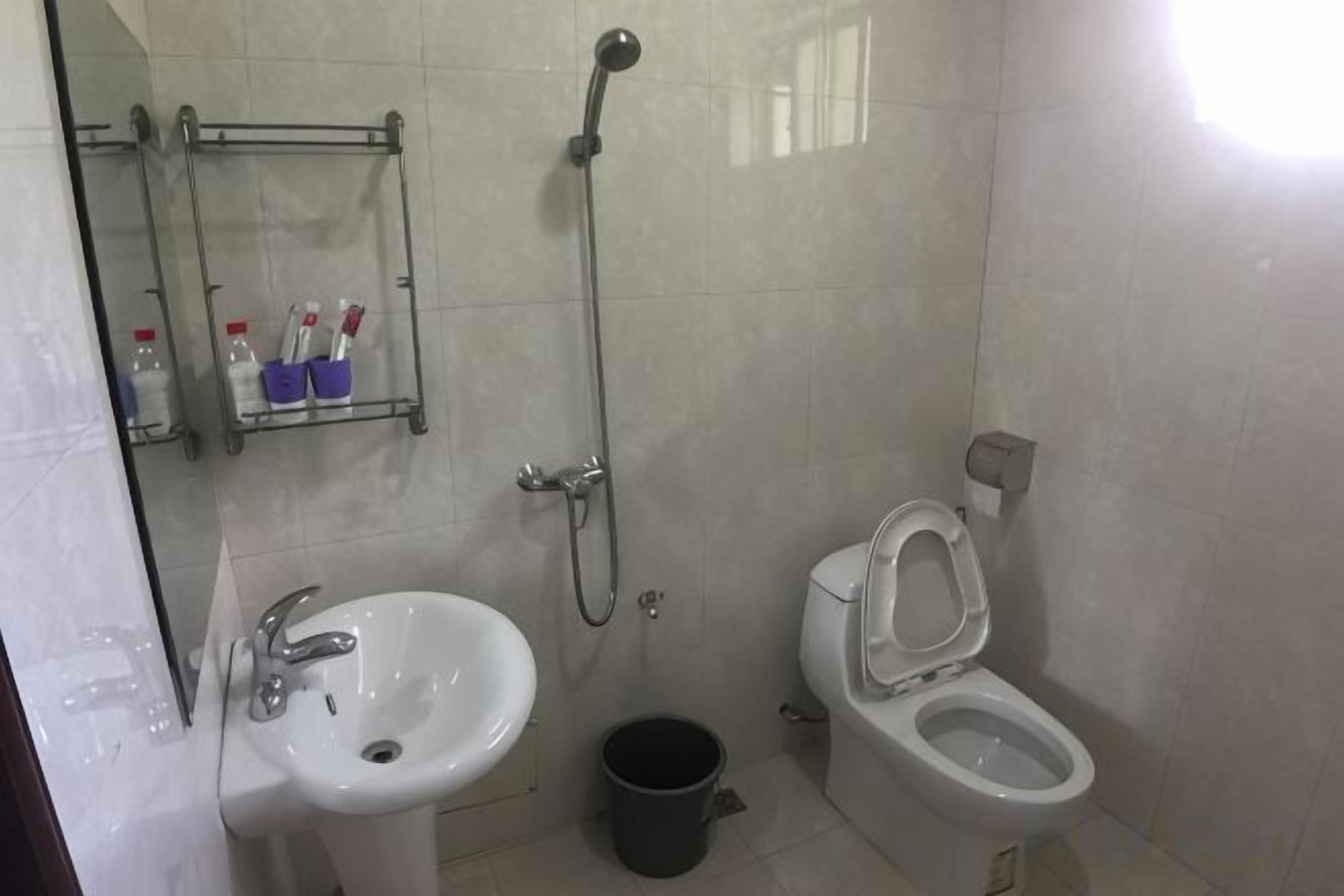 A bathroom with a sink, toilet, and shower.