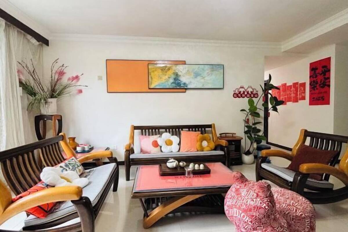 A living room with a sofa, chairs, a coffee table, and wall art.