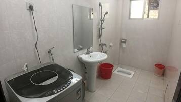 Un baño con lavamanos, espejo, ducha y retrete.