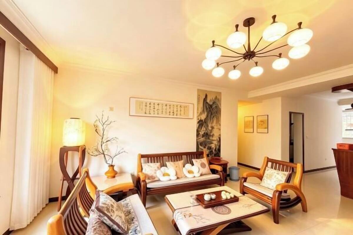 A traditional-style living room with a sofa, chairs, a coffee table, and a decorative lamp.