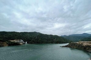 Un río con un puente y colinas al fondo.