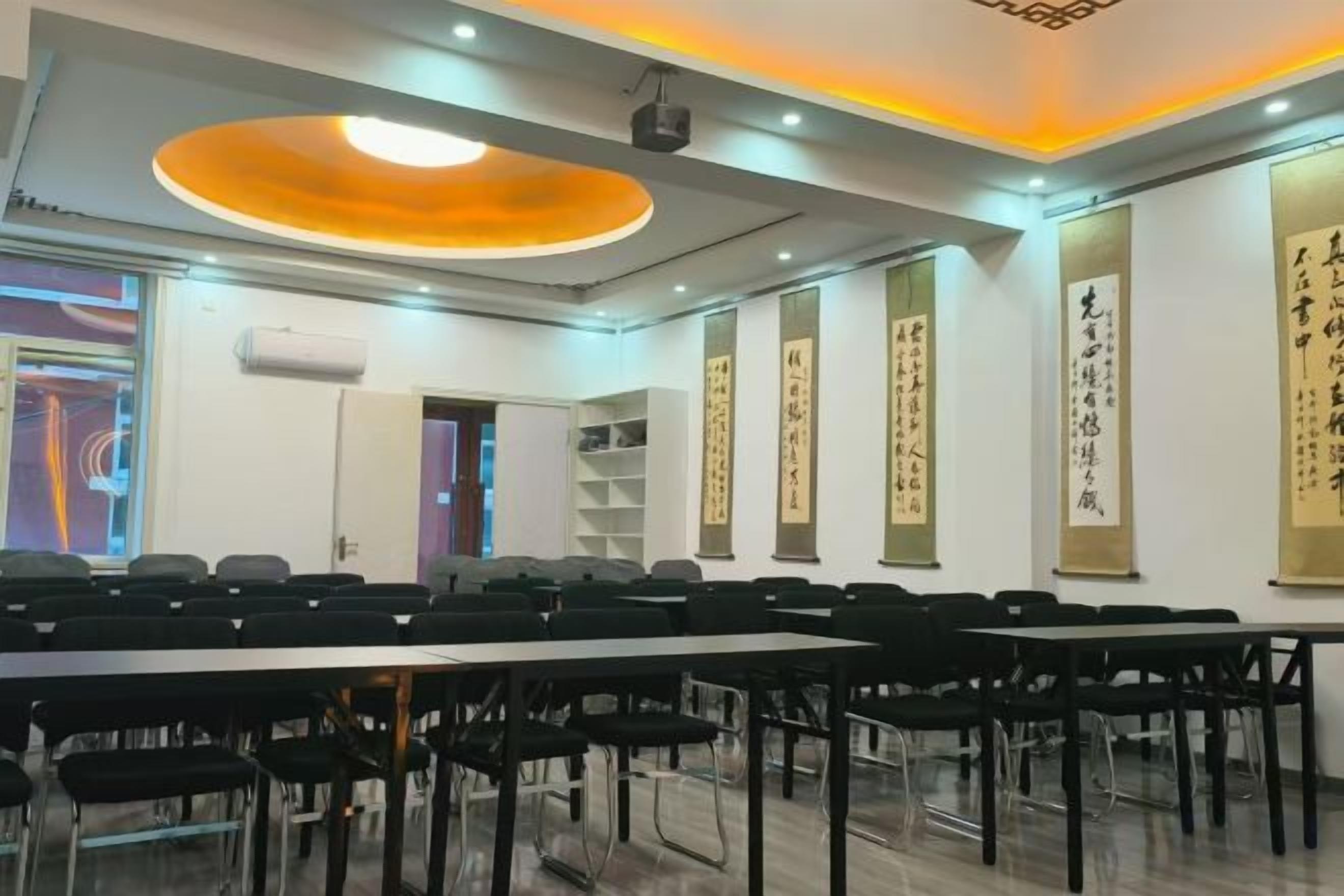 A conference room with a long table, chairs, and a projector screen.