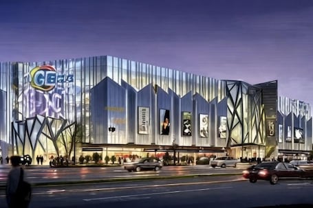 A modern building with a distinctive geometric facade, large illuminated signage, and a prominent entrance.. Huayi Hotel (Harbin CapitaLand Airport Bus Station)
