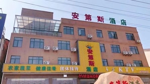 A hotel building with multiple floors, air conditioning units, and a signboard with Chinese characters. - Andes Hotel Pingjiang (Pingjiang)