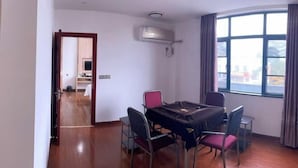 A room with a dining table, four chairs, a ceiling-mounted air conditioner, and a large window with curtains. - Andes Hotel Pingjiang (Pingjiang)