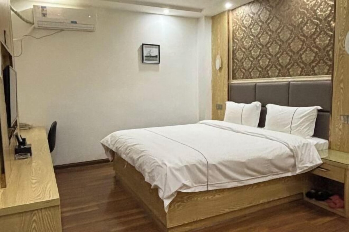 Un dormitorio con una cama de madera, un escritorio y una silla.