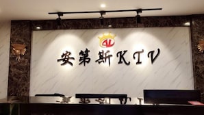 A reception desk with a marble wall and a logo above it. - Andes Hotel Pingjiang (Pingjiang)