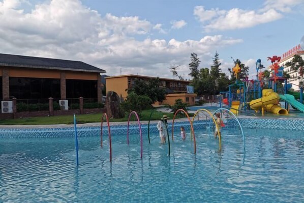 A swimming pool with colorful slides and a water park area.