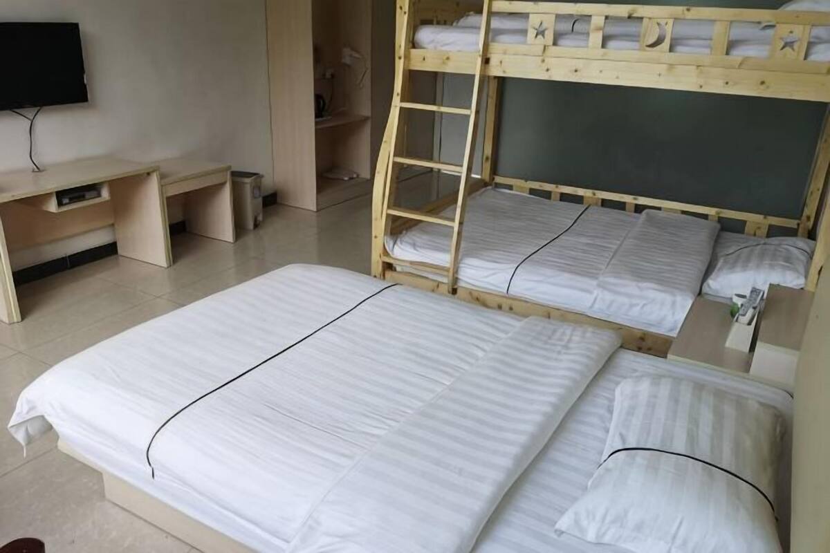 Habitación con literas, escritorio y televisor.