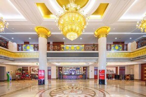 A spacious lobby with a grand chandelier, multiple floors, and traditional decor. - Yanzi Resort (Jinan)
