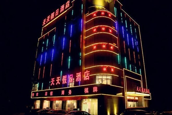 A multi-story hotel with illuminated signage and a prominent entrance. - Tiantian Holiday Hotel (Tongcheng)