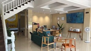 Een moderne woonkamer met een trap, een bank, een salontafel en een werkhoek.