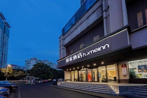 Un hotel con fachada moderna, amplios ventanales y señalización llamativa.